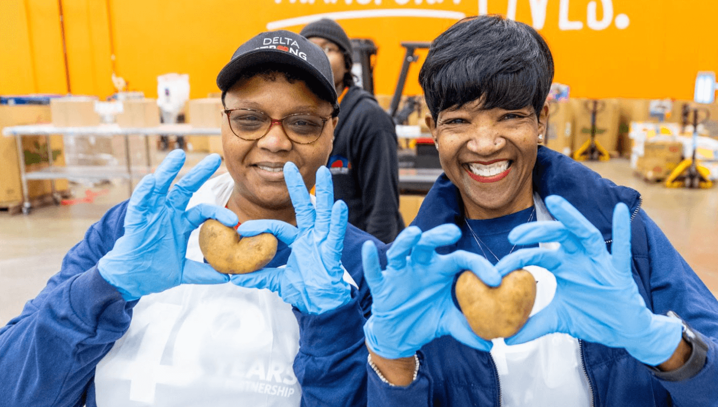 Food Bank volunteers holding heart-shaped potatoes.