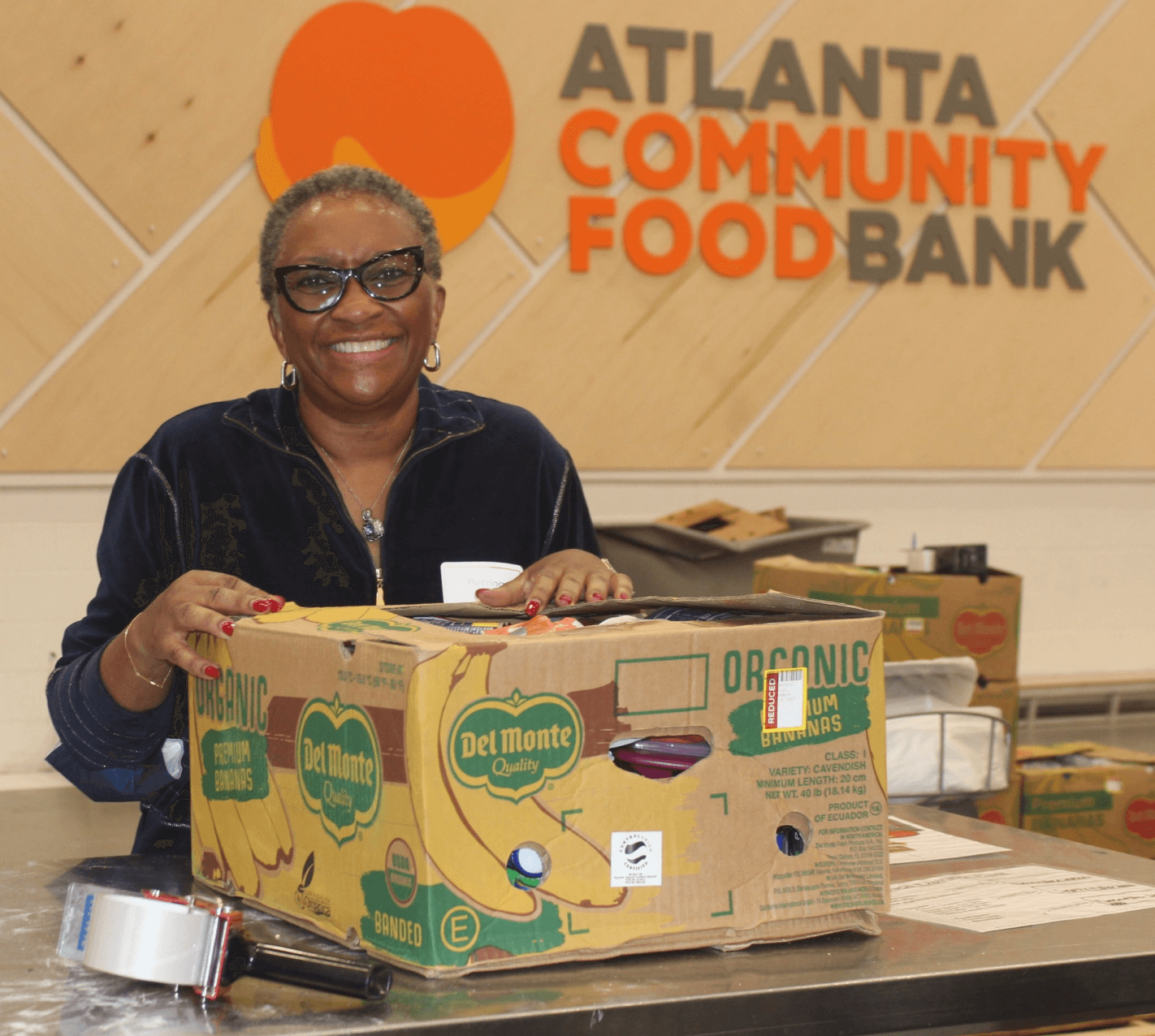 Woman with glasses volunteering at the Atlanta Community Food Bank.