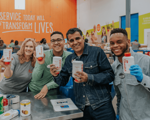 Smiling volunteers holding CFA sauce